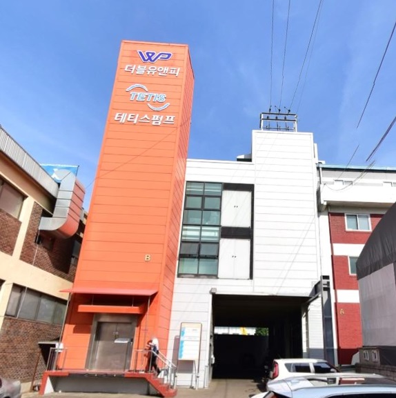 WNP Korea is written in white, and it is an exterior view of the company with a white background and brown close to orange.