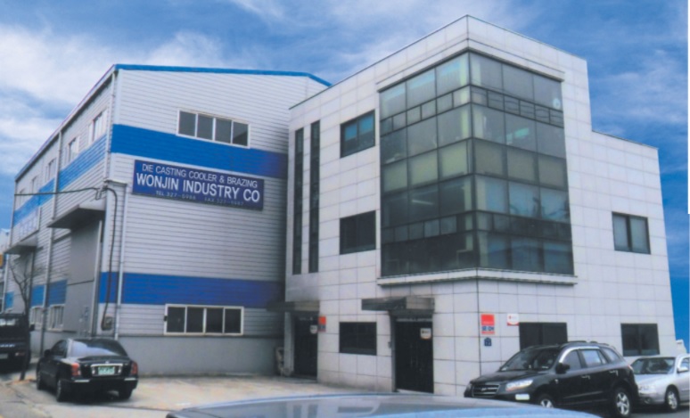 The office building of Wonjin Industries, which looks like a three-story building, can also be seen with a parking lot and 4 cars.