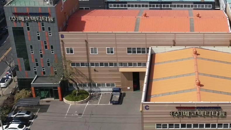 The image of Mecotec Titanium Company was taken with a drone, overlooking the entire company from the sky, and the parking lot is also visible.